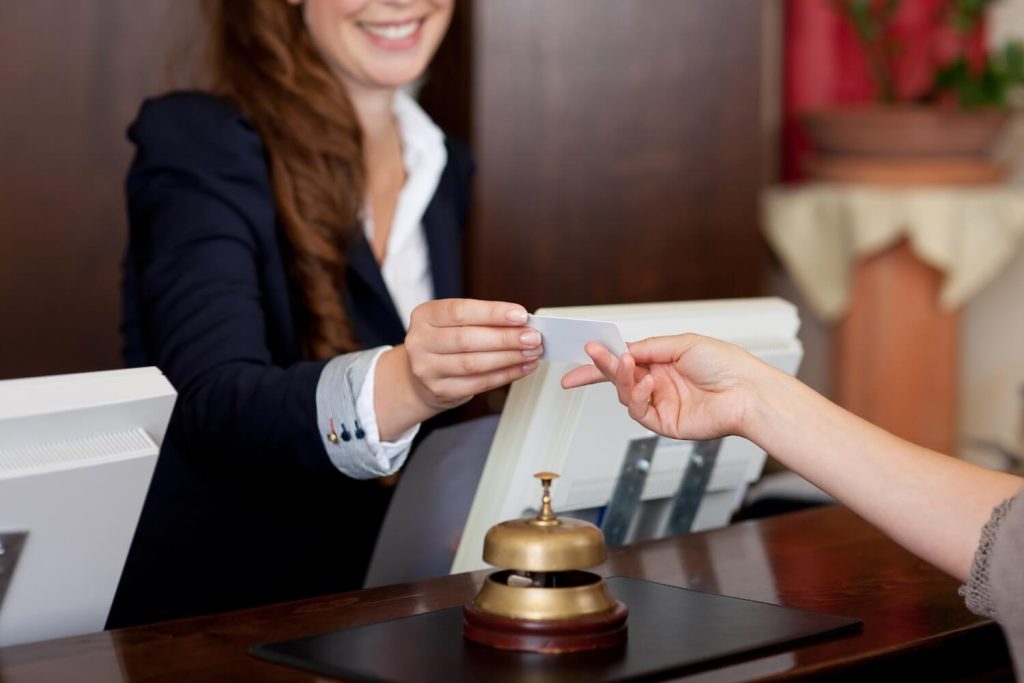 Jahresarbeitszeitkonto ermöglicht flexibles Arbeiten - Hotelrezeptionistin bedient Gäste